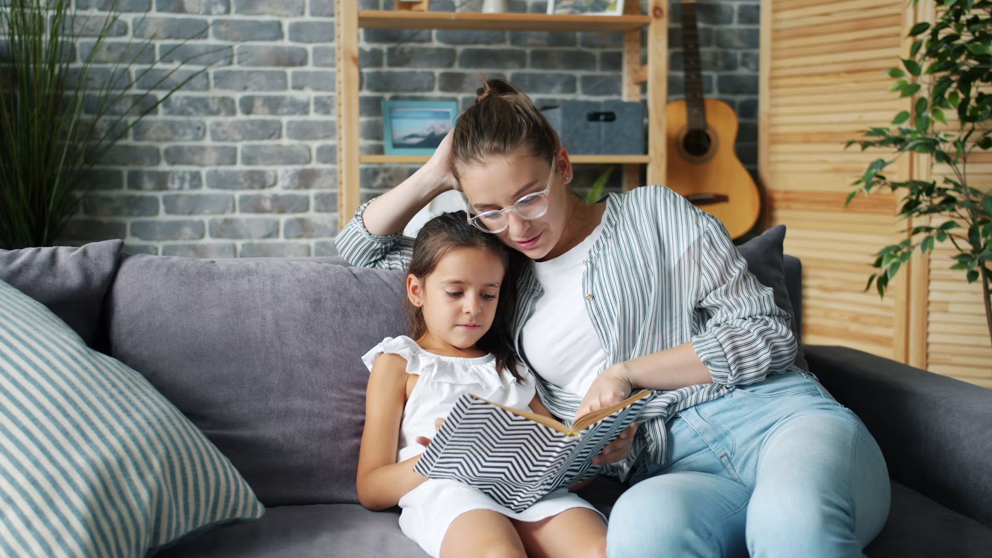 Parent and child reading together on a couch